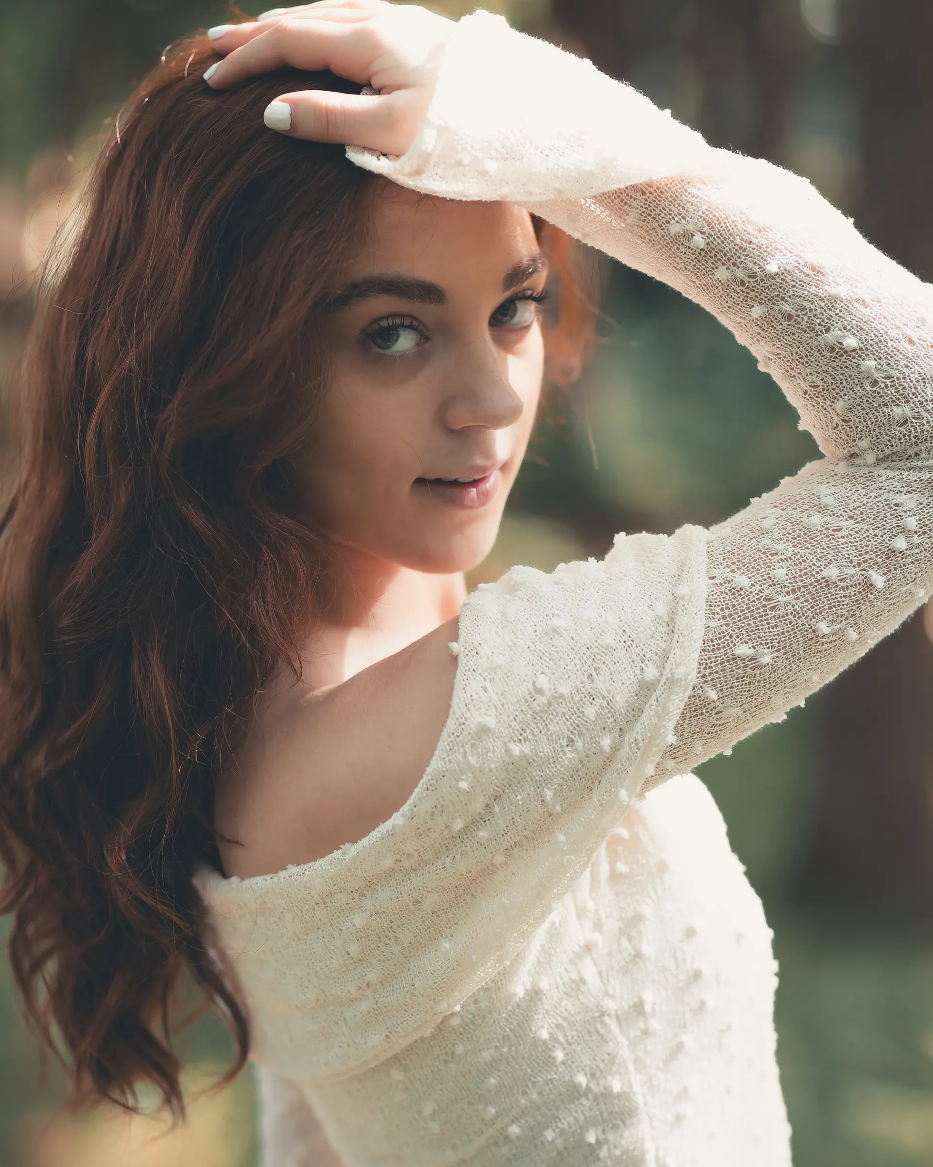 Portrait of Rosalinn in the forest, hand shading her eyes.
