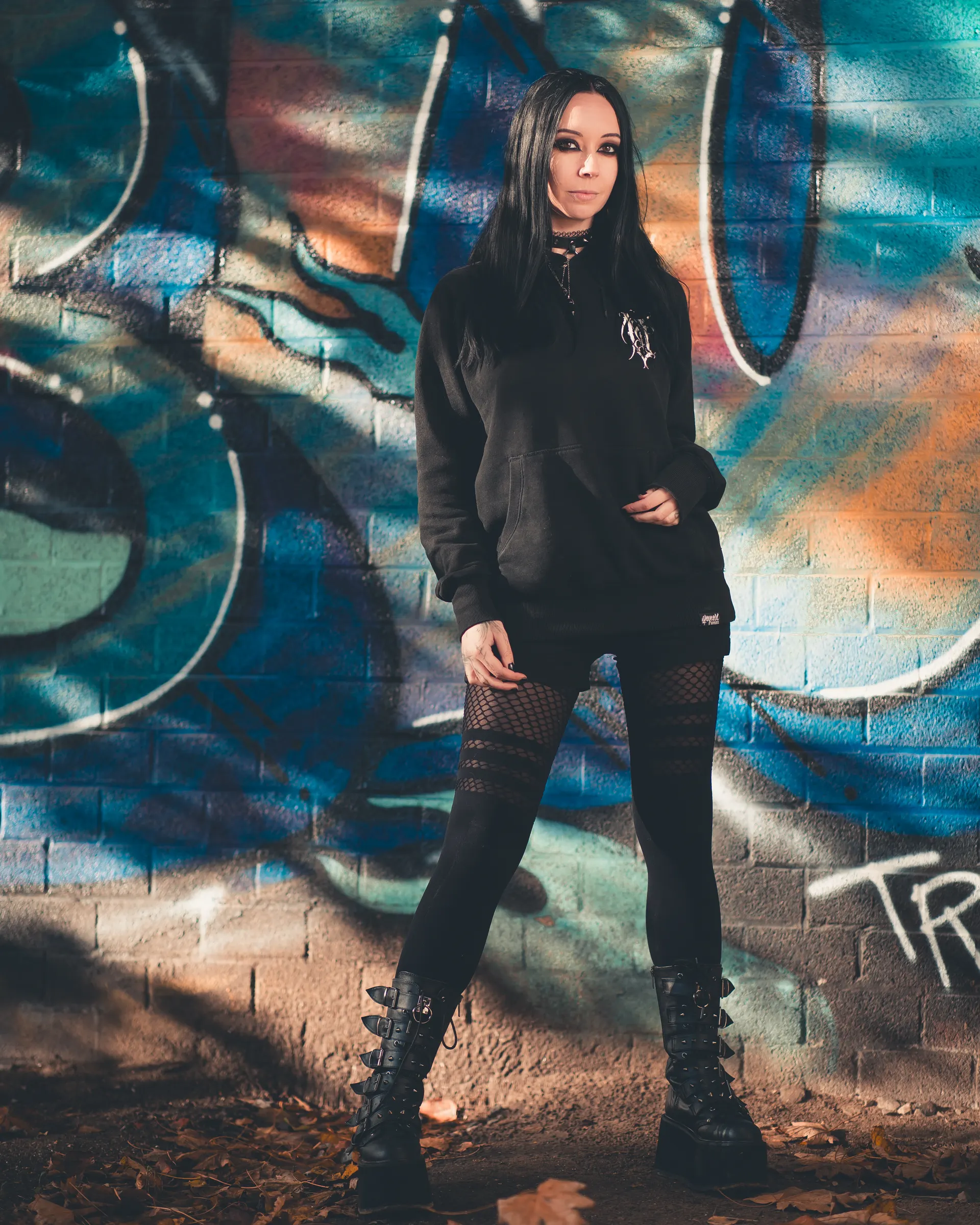Urban portrait of Marlou, gothic styling, graffiti backdrop.